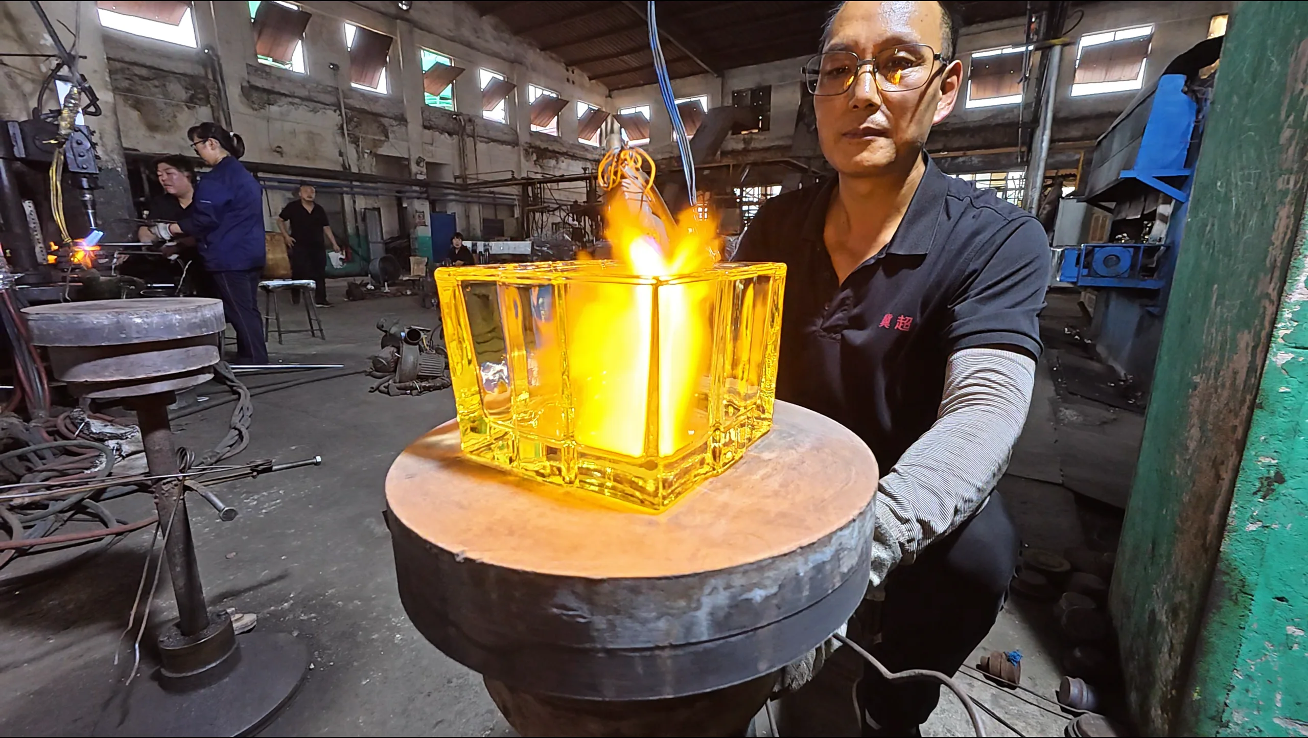 Glass worker inspecting a pressed glass object